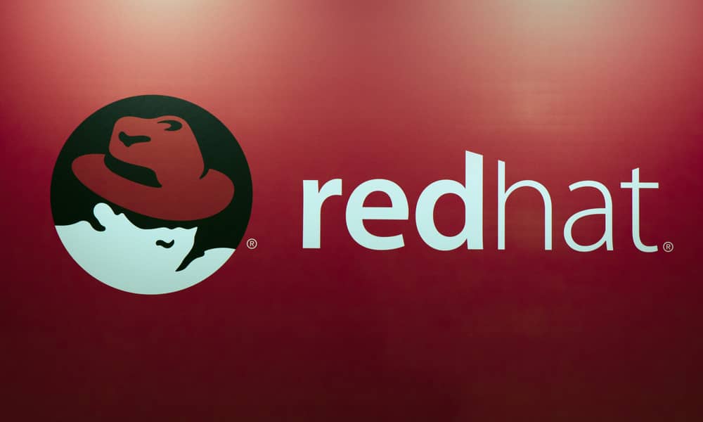 Logo de Red Hat sobre fondo rojo, símbolo de la Historia de Red Hat y su impacto en el open source.